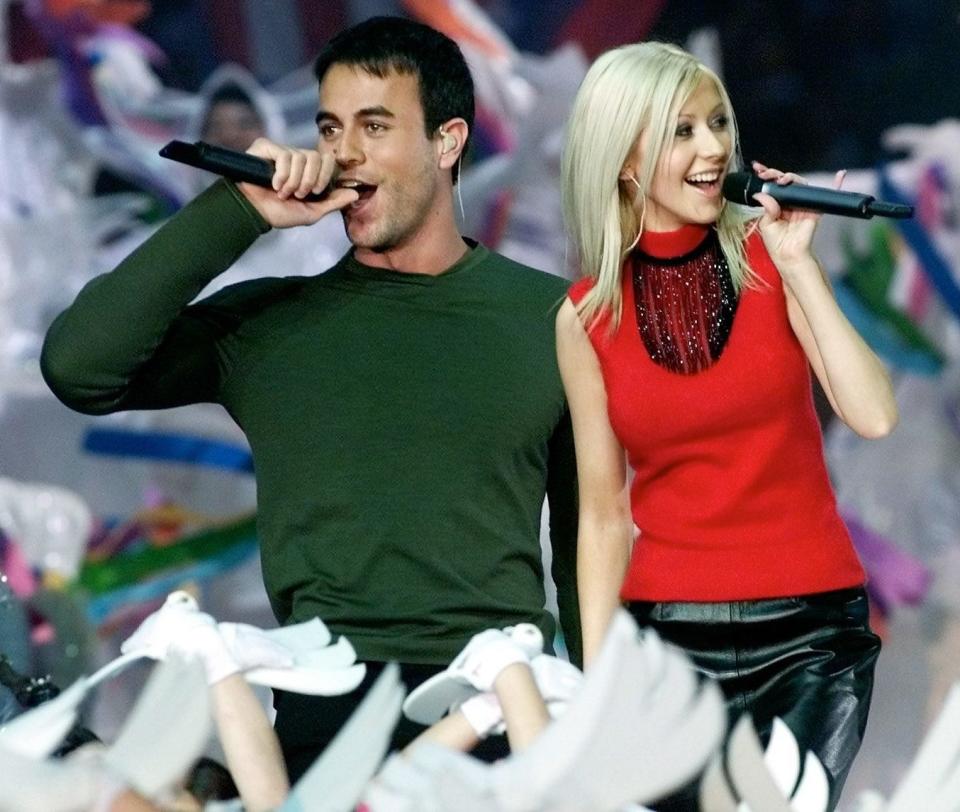 Singers Christina Aguilera (R) and Enrique Iglesias (L) perform during the halftime show at Super Bowl XXXIV