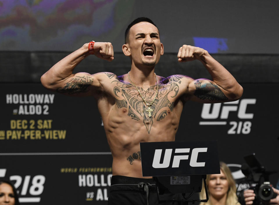 UFC featherweight champion Max Holloway reacts for the crowd during weigh-in before challenger Jose Aldo came on stage, Friday, Dec. 1, 2017 at Little Caesars Arena in Detroit.  (AP Photo/Jose Juarez)