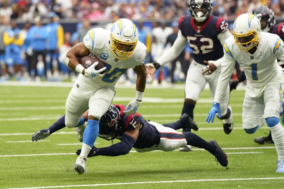 Chargers running back Austin Ekeler runs past Houston Texans safety Jalen Pitre to score a touchdown.