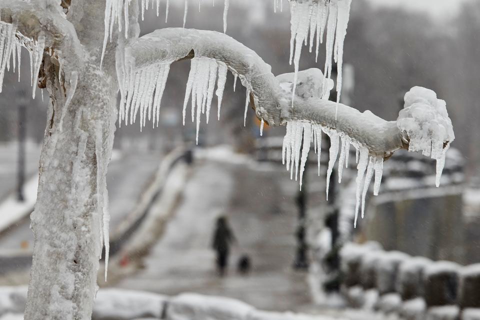 A woman walks her dog in the distance, along the Niagara Parkway in Niagara Falls, Ontario, on January 27, 2021. (Photo by Geoff Robins / AFP) (Photo by GEOFF ROBINS/AFP via Getty Images)