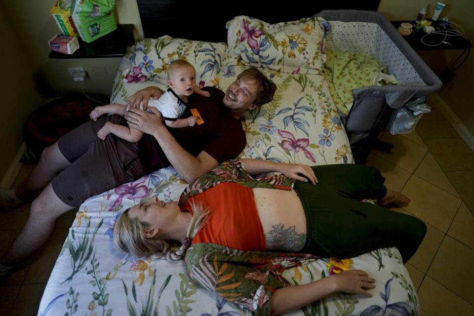 Russian nationals Alla Prigolovkina and Andrei Ushakov spend time with their Argentine-born son Lev Andres, in the bedroom of their home in Mendoza, Argentina, Tuesday, Feb. 14, 2023. Prigolovkina says that obtaining a passport for their newborn son, Lev Andres, was a motivating factor for the move to Argentina: “We wanted our baby to have the chance to not just be Russian and have a single passport.” (AP Photo/Natacha Pisarenko)