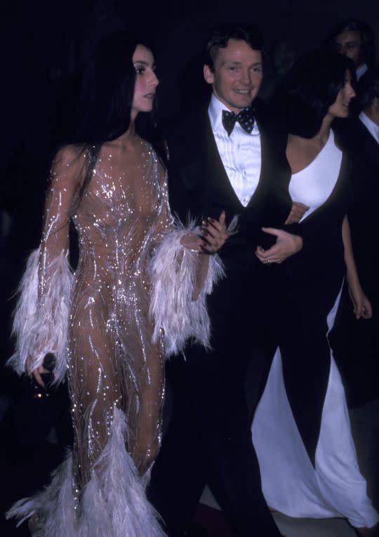 <p>The one-named wonder wore a custom creation by Bob Mackie for the second official gala in 1974. Her hair was sleek, her makeup was strong, but the drama was all in the dress. The sheer fabric, adorned with rhinestones and feathers, was pure perfection. (Photo: Getty Images) </p>