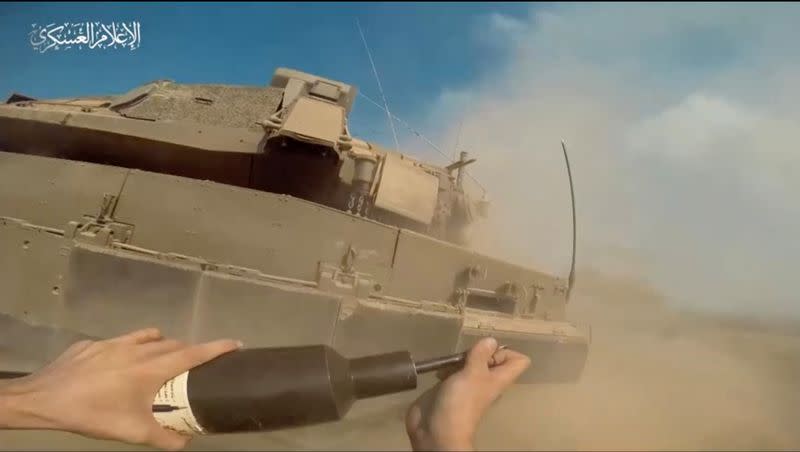 A still image taken from a video released by Hamas shows what it says a Palestinian Hamas fighter placing an explosive on an Israeli tank in Gaza Strip