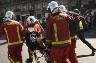 An injured man is carried away by emergency personnel during a yellow vest demonstration in Paris, Saturday, April 20, 2019. French yellow vest protesters are marching anew to remind the government that rebuilding the fire-ravaged Notre Dame Cathedral isn't the only problem the nation needs to solve. (AP Photo/Francisco Seco)