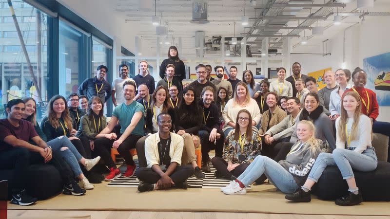 Employees of fintech firm Project Imagine pose for a photo in their office in London