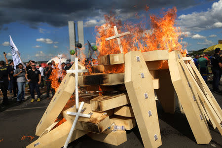 Striking police officers set fire to coffins during a protest by Police officers from several Brazilian states against pension reforms proposed by Brazil's president Michel Temer, in Brasilia, Brazil April 18, 2017. REUTERS/Adriano Machado