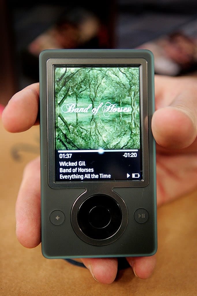 hand holding up a zune showing band of horses playing