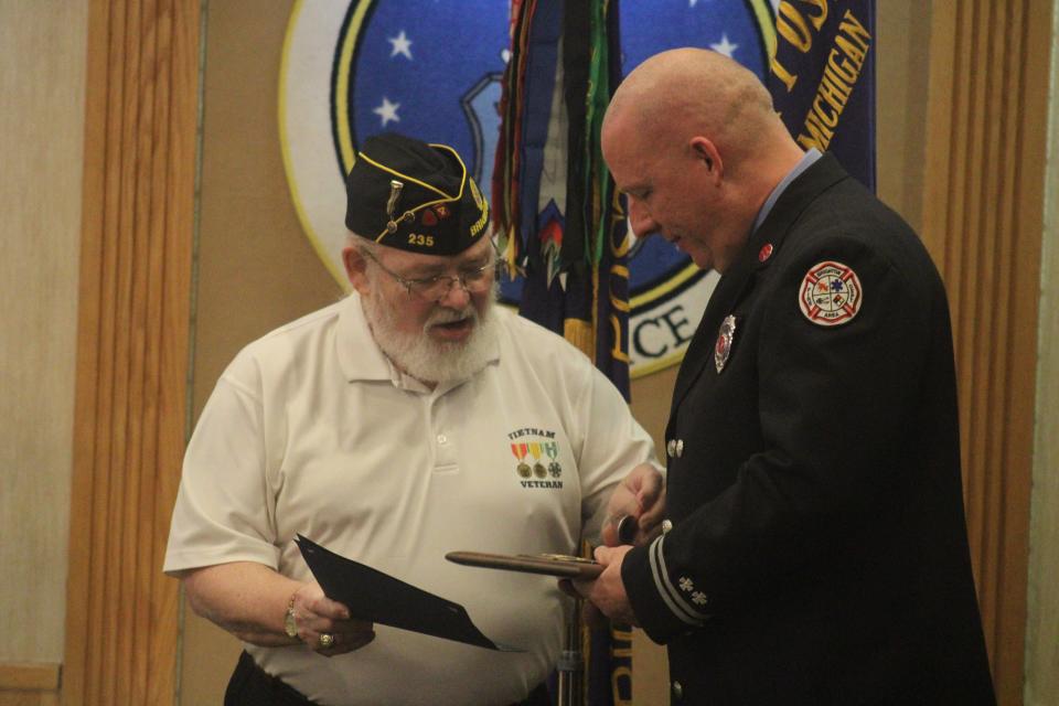 American Legion Post 235 Commander Mike Omstead presents a plaque and challenge coin to Brighton Area Fire Authority Captain/Fire Inspector Derrick Bunge.