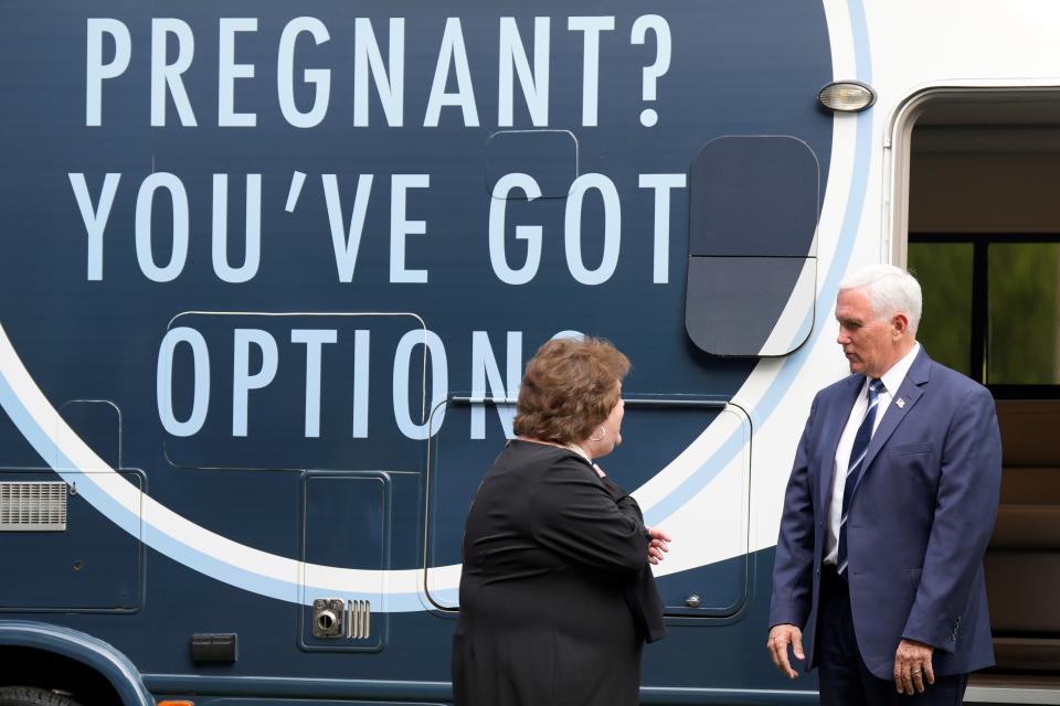 Former Vice President Mike Pence speaks to Carolina Pregnancy Center director Alexia Newman next to a mobile ultrasound unit.