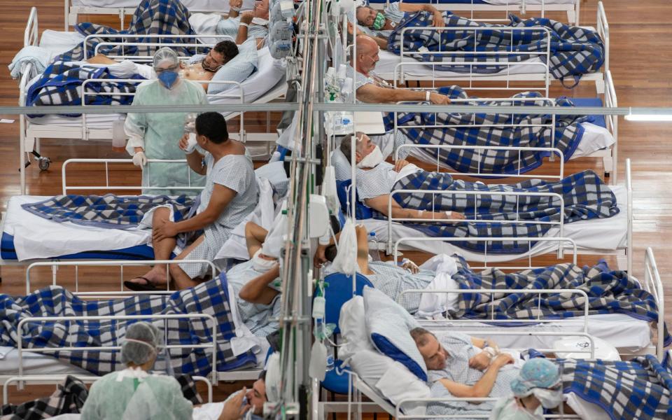 Covid-19 patients lie on beds in a field hospital built inside a gym in Santo Andre, on the outskirts of Sao Paulo, Brazil - AP