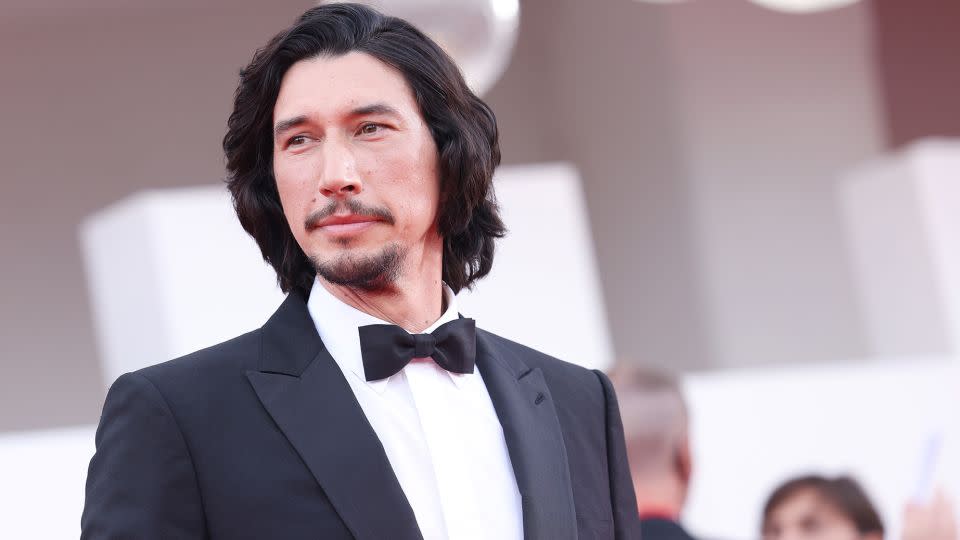 Actor Adam Driver in a suave black tuxedo on the red carpet for the biopic "Ferrari." - Stefania D'Alessandro/WireImage/Getty Images