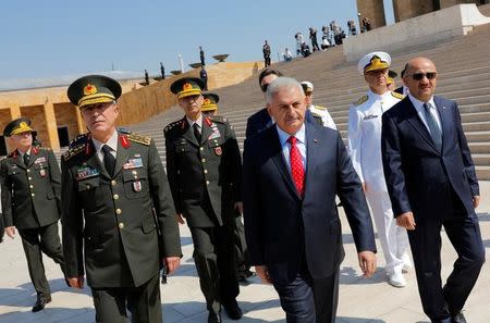 Turkey's Prime Minister Binali Yildirim (C), flanked by Chief of Staff General Hulusi Akar (L), Defense Minister Fikri Isik (R) and the country's top generals, leaves Anitkabir, the mausoleum of modern Turkey's founder Mustafa Kemal Ataturk, after a wreath-laying ceremony ahead of a High Military Council meeting in Ankara, Turkey, July 28, 2016. REUTERS/Umit Bektas