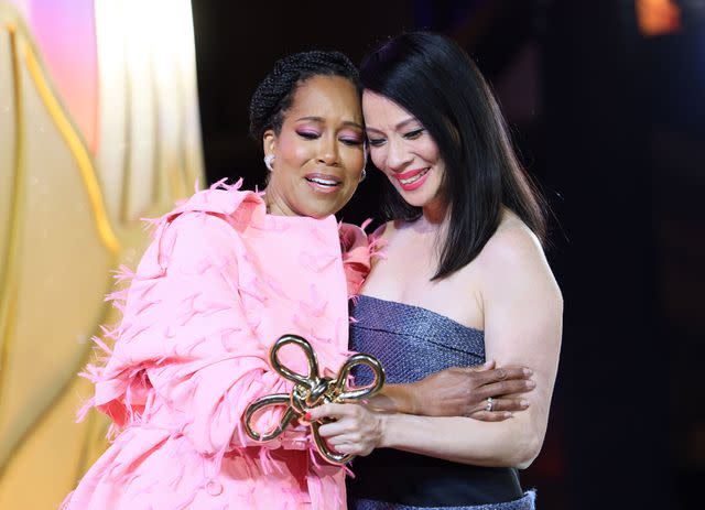 <p>Rodin Eckenroth/Getty</p> Regina King (left) presents Lucy Liu the Gold Legend Award at the 2024 Gold Gala on May 11, 2024