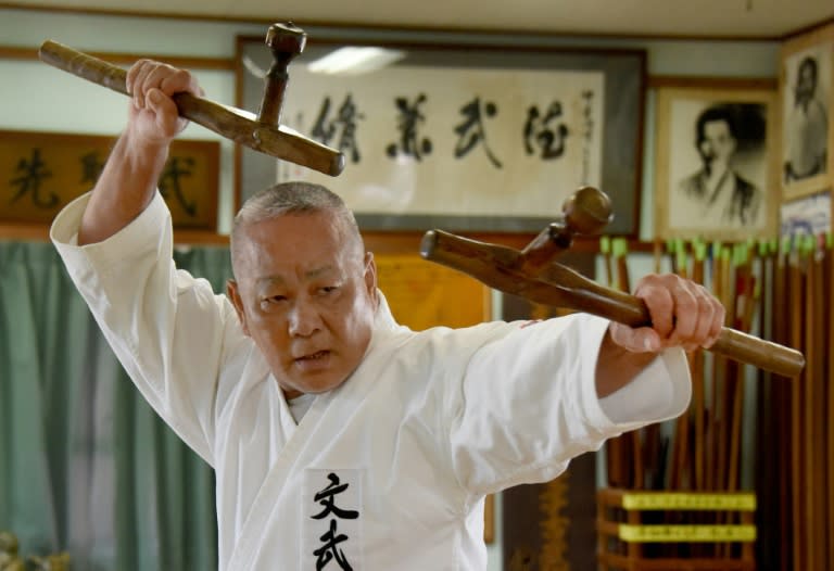 Karate master Takashi Nakamori, a high-ranking expert of the Okinawa Kobudo traditional weapons system, using a pair of 'tonfa' to demonstrate his skills at a training hall in Naha