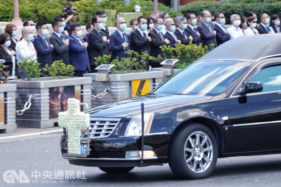 載運李登輝遺體的車隊繞行總統府一周，總統府副秘書長李俊俋（前排左起）、劉建忻、李大維、國安會秘書長顧立雄等率隊在府前廣場向李登輝敬禮致意。（中央社）