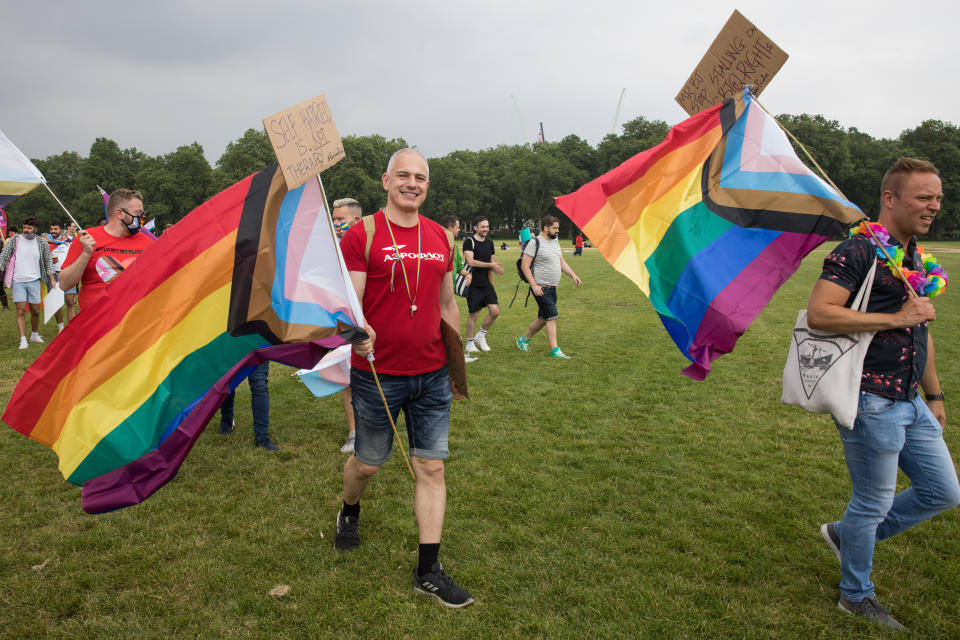LGBTI+ protesters hold Progress Pride flags as the first-ever Reclaim Pride march arrives in Hyde Park for a Queer Picnic on 24th July 2021 in London, United Kingdom. Reclaim Pride replaced the traditional Pride in London march, which many feel has become too commercial and strayed from its roots in protest, and was billed as a Peoples Pride march for LGBTI+ liberation. Campaigners called for the banning of LGBTI+ conversion therapy, the reform of the Gender Recognition Act, the provision of a safe haven for LGBTI+ refugees and for LGBTI+ people to be decriminalised worldwide and marched in solidarity with Black Lives Matter. (photo by Mark Kerrison/In Pictures via Getty Images)