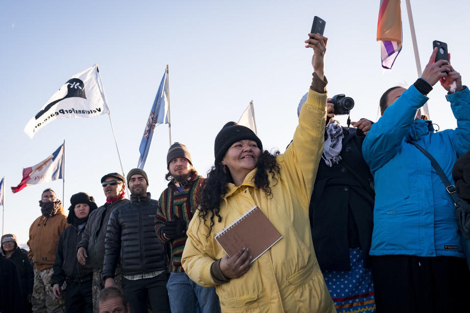 Dakota Access Pipeline protesters celebrate as they watch a group of veterans march into the Oceti Sakaowin camp.