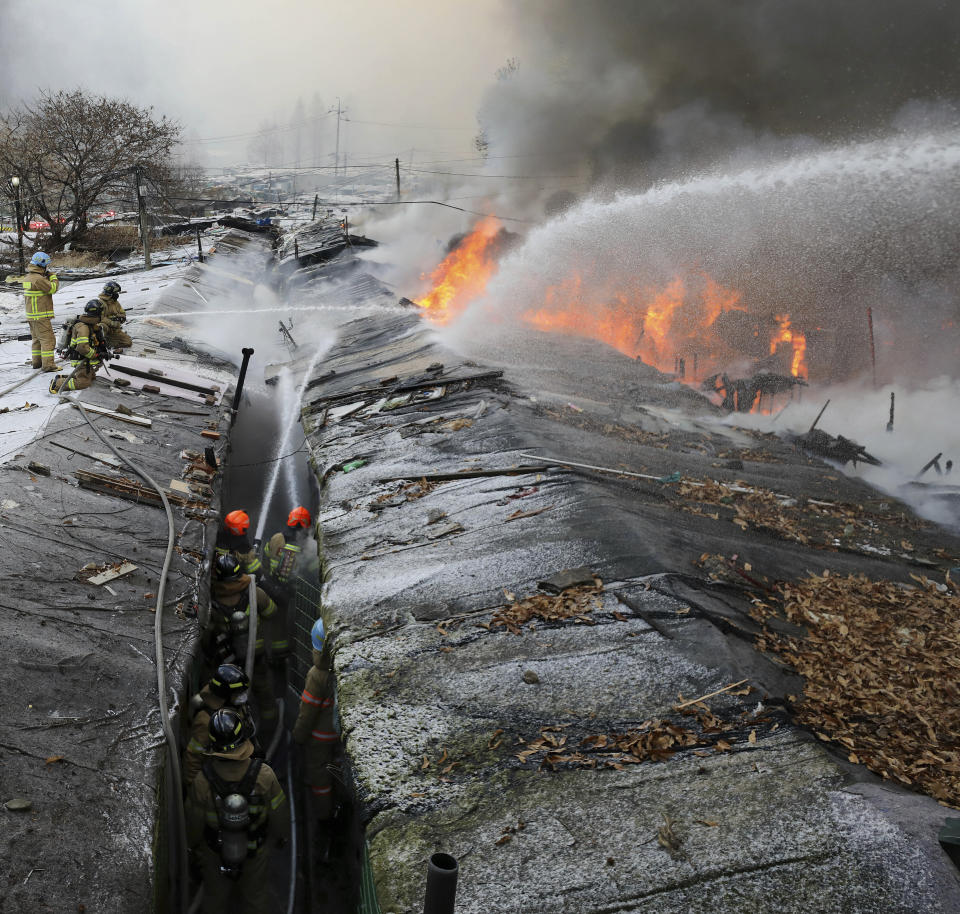 Firefighters battle a fire at Guryong village in Seoul, South Korea, Friday, Jan. 20, 2023. About 500 South Koreans were forced to flee their homes after a fire spread through a low-income neighborhood in southern Seoul on Friday morning and destroyed dozens of homes. (Baek Dong-hyun/Newsis via AP)