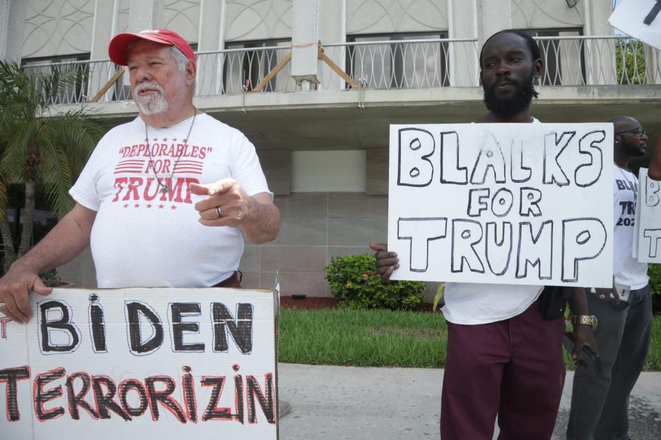 Bob Kunst, left, of Miami Beach, and other Trump supporters stand outside the federal courthouse in West Palm Beach on September 1, 2022.