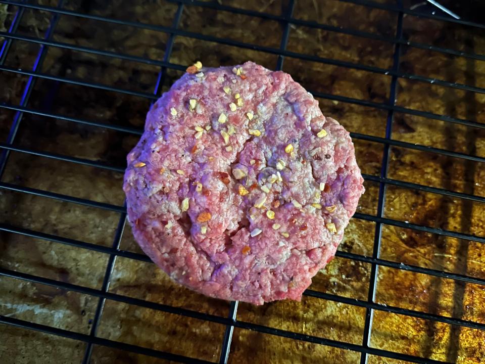 raw burger patty cooking in an oven
