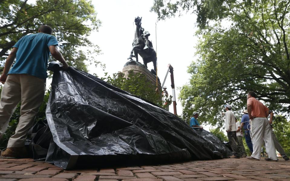 Richmond, Va., city workers prepare to drape a tarp over a statue of Confederate Gen. Stonewall Jackson in 2017. <a href="https://newsroom.ap.org/detail/ConfederateMonumentsProtest/31b060bdbdd84f349a5bc96319bcccc3/photo" rel="nofollow noopener" target="_blank" data-ylk="slk:AP Photo/Steve Helber;elm:context_link;itc:0;sec:content-canvas" class="link ">AP Photo/Steve Helber</a>