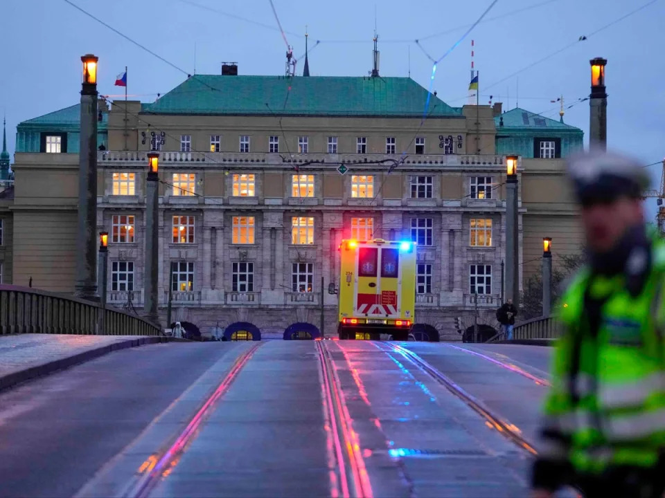 An ambulance drives towards the building of Philosophical Faculty of Charles University in Prague (AP)