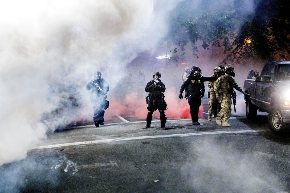 Federal officers use crowd control munitions to disperse Black Lives Matter protesters outside the Mark O. Hatfield United States Courthouse on Tuesday, July 21, 2020, in Portland, Ore. (AP Photo/Noah Berger)