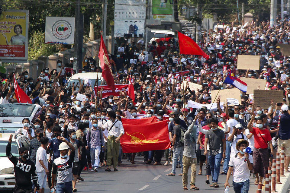 A crowd of protesters march in Yangon, Myanmar Sunday, Feb. 7, 2021. About 2,000 protesters rallied against the military takeover in Myanmar's biggest city on Sunday and demanded the release of Aung San Suu Kyi, whose elected government was toppled by the army that also imposed an internet blackout. (Kyodo News via AP)