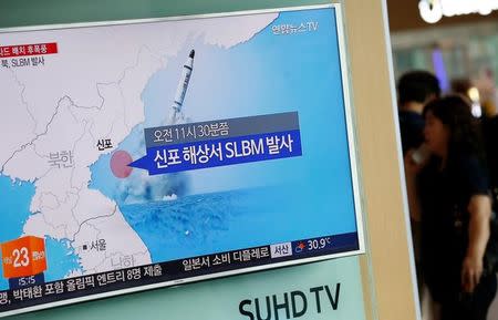 A passenger walks past a TV screen at a railway station in Seoul, South Korea, broadcasting a news report on North Korea's submarine-launched ballistic missile fired from North Korea's east coast port of Sinpo July 9, 2016. REUTERS/Kim Hong-Ji