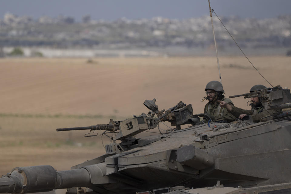 Israeli soldiers move on the top of a tank near the Israeli-Gaza border, as seen from southern Israel, Tuesday, April 9, 2024. (AP Photo/Leo Correa)