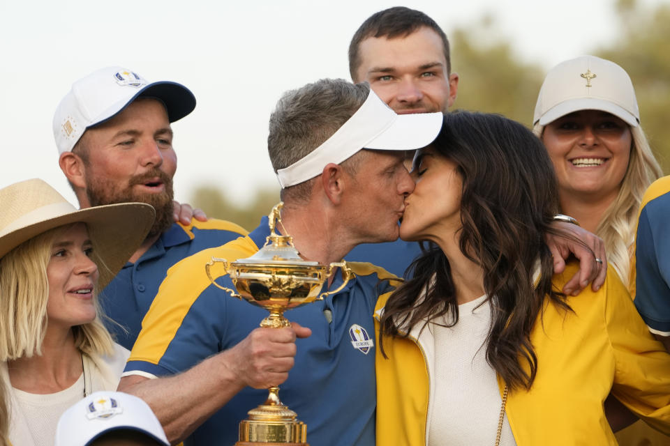 Europe's Team Captain Luke Donald , centre, kisses his wide Diane as they pose for the camera after winning the trophy by defeating the United States 16/12 point to 11 1/2 points at the Marco Simone Golf Club in Guidonia Montecelio, Italy, Sunday, Oct. 1, 2023. (AP Photo/Alessandra Tarantino)