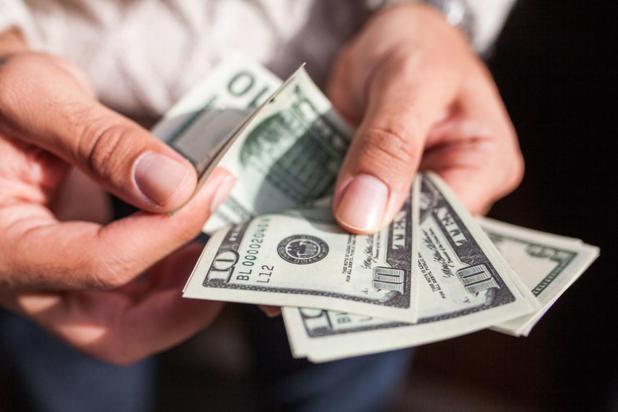 man's hands counting dollars