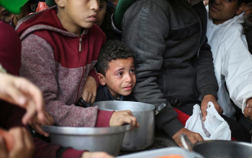 Palestinians line up for free food distribution in Khan Younis