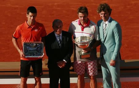 Switzerland's Stanislas Wawrinka celebrates with the trophy after winning the final with Former Brazilian tennis player Gustavo Kuerten (R) and French Tennis Federation President Jean Gachassin as Serbia's Novak Djokovic looks on with his runners up trophy. Action Images via Reuters / Jason Cairnduff