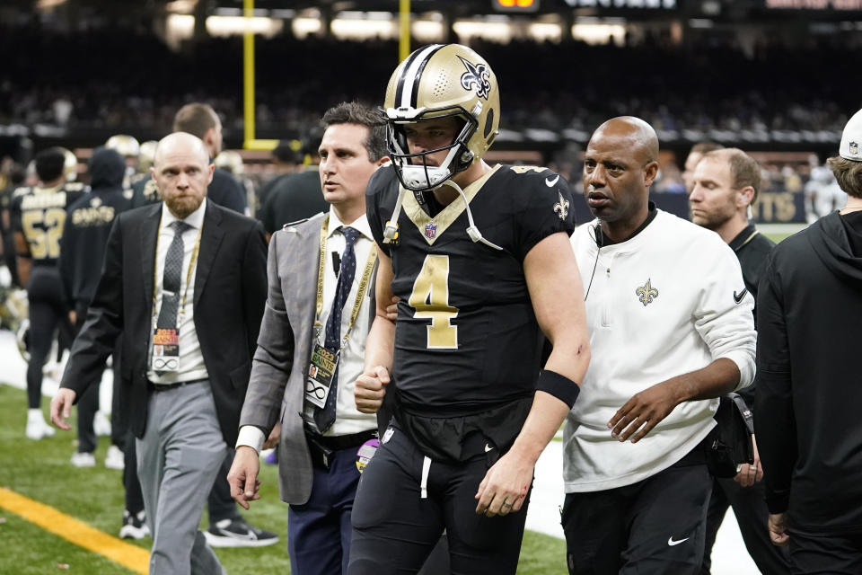 New Orleans Saints quarterback Derek Carr (4) is helped off the field during the second half of an NFL football game against the Detroit Lions, Sunday, Dec. 3, 2023, in New Orleans. (AP Photo/Gerald Herbert)