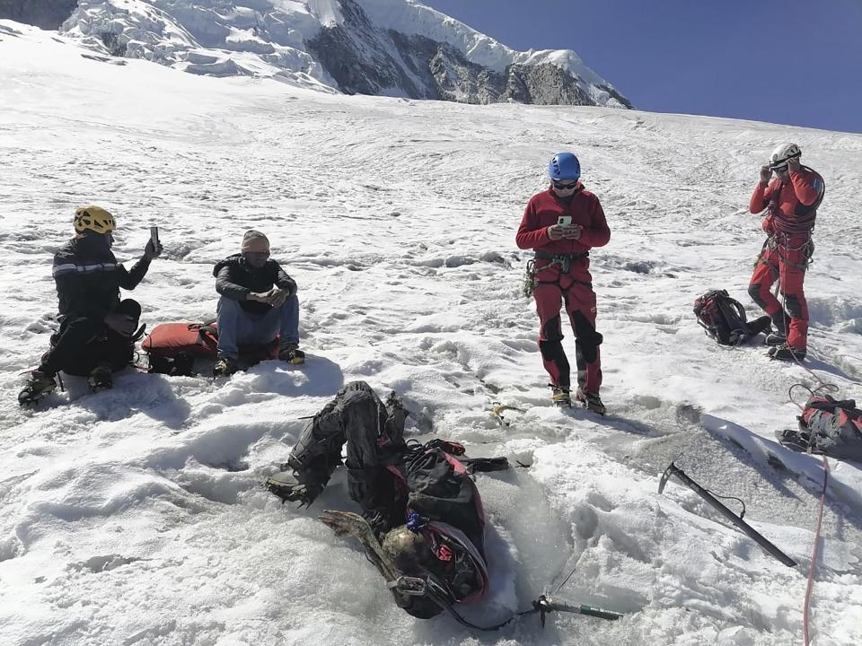 Esta fotografía distribuida por la Policía Nacional de Perú muestra a agentes rodeando el cuerpo de quien identificaron como el montañista estadounidense William Stampfl, en la montaña Huascarán en Huraz, Perú, el 5 de julio de 2024. Las autoridades peruanas anunciaron el martes 9 de julio de 2024 que han encontrado el cuerpo momificado del hombre estadounidense que murió hace 22 años, junto con otros dos alpinistas estadounidenses, después de que los tres quedaran atrapados en una avalancha mientras intentaban escalar la montaña más alta de Perú. (Policía Nacional de Perú vía AP)