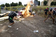 Squatters set fire to a barricade created outside an abandoned school before being evicted, on the outskirts of Rome, Monday, July 15, 2019. Residents set fire early Monday to mattresses and other garbage to form a barrier and prevent riot police from entering the building but authorities doused the blaze and proceeded with the eviction. (Massimo Percossi/ANSA via AP)