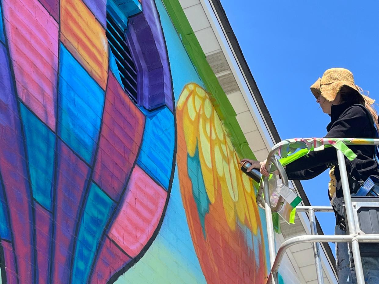 Artist Sarah Hout places final touches June 19 on a mural at Ross Realtors, 3988 Main St., in Old Hilliard.