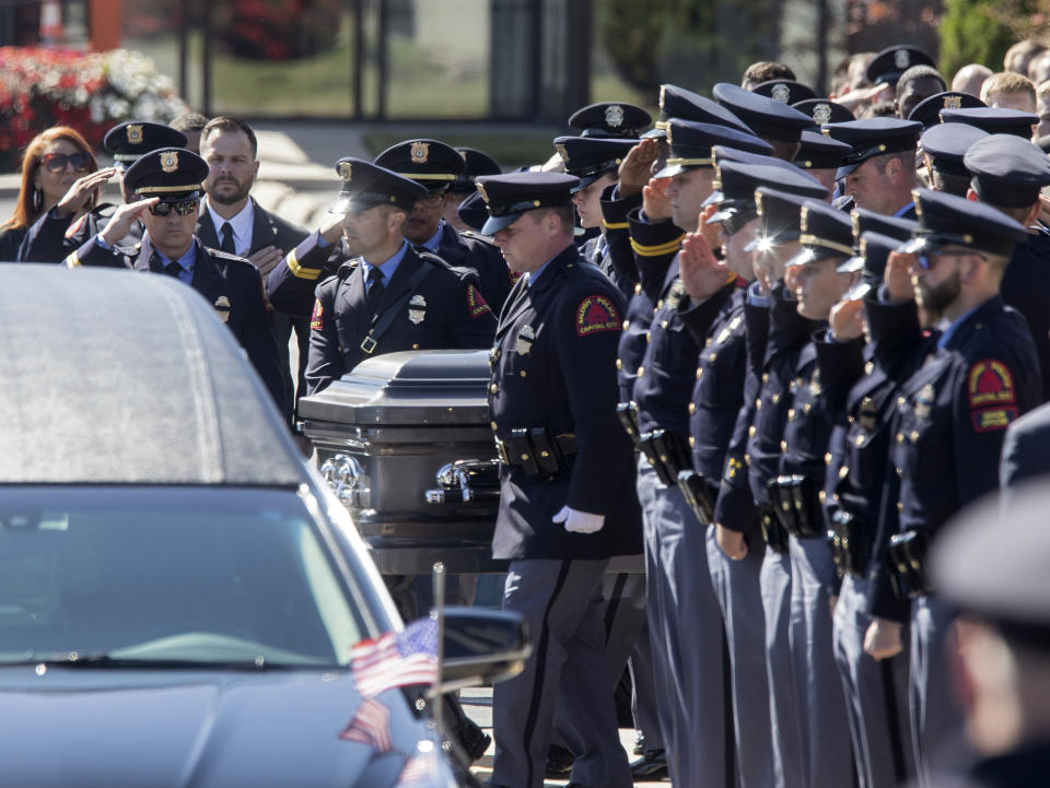 Police salute as the casket of Raleigh police officer Gabriel Torres leaves Cross Assembly Church following his funeral on Saturday, Oct. 22, 2022, in Raleigh, N.C. Torres, a Raleigh police officer and former U.S. Marine, was inside his personal vehicle and about to leave for work when authorities said he was shot by a 15-year-old boy wearing camouflage clothing and firing a shotgun. 9Kaitlin McKeown/The News & Observer via AP)