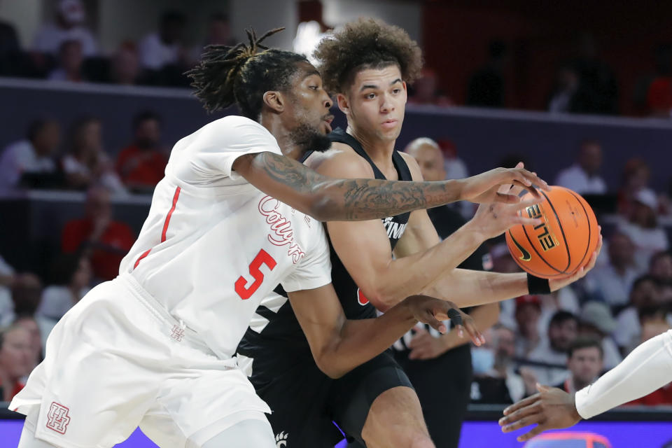 Houston forward Ja'Vier Francis (5) reaches for the ball as Cincinnati guard Dan Skillings Jr. drives to the basket during the first half of an NCAA college basketball game Tuesday, Feb. 27, 2024, in Houston. (AP Photo/Michael Wyke)