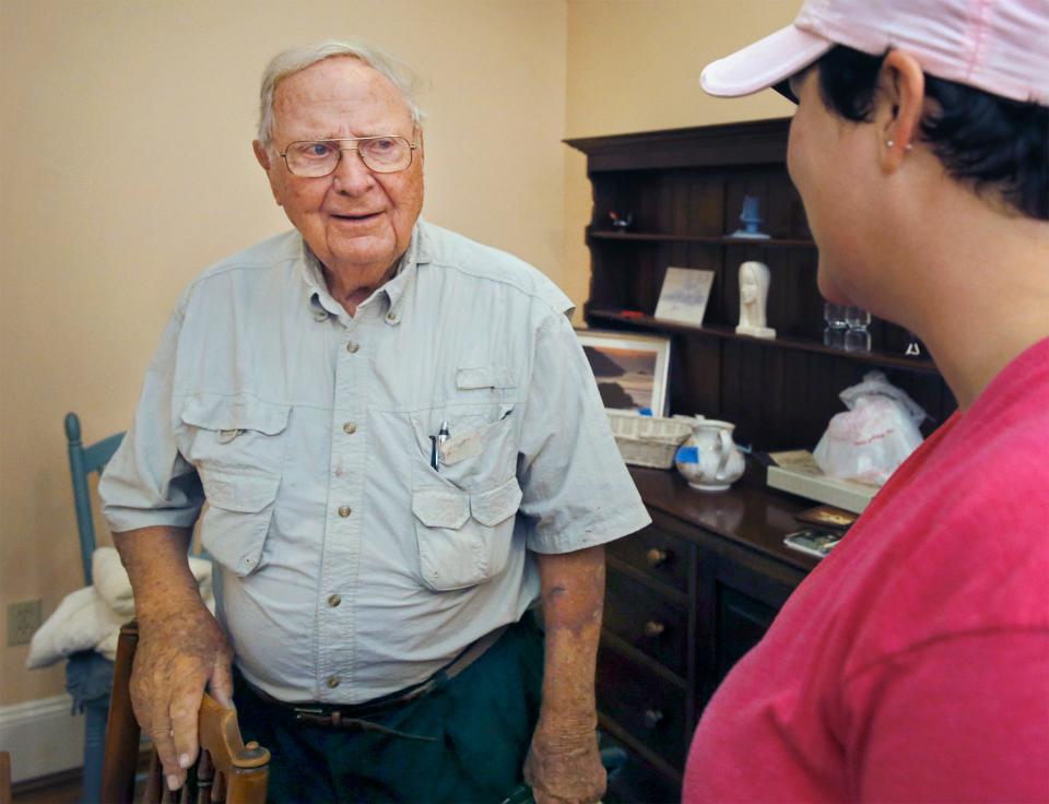 Tom Shaw, left, talks with Gwen Allen during the sale of furnishings at the Shaw house bed and breakfast in Lakeland on April 14,  2018.