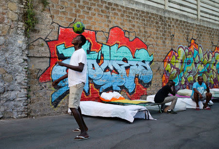 A migrant balances a ball at a makeshift camp in Via Cupa (Gloomy Street) in downtown Rome, Italy, August 2, 2016. REUTERS/Max Rossi