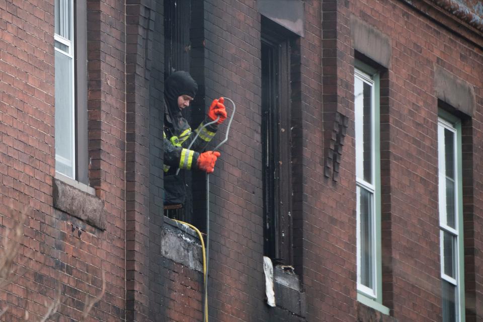 A firefighter pulls up a hose at the scene of a fatal fire on the 800 block of N. 23rd Street in Philadelphia, Pa. on Wednesday, Jan. 5, 2022.