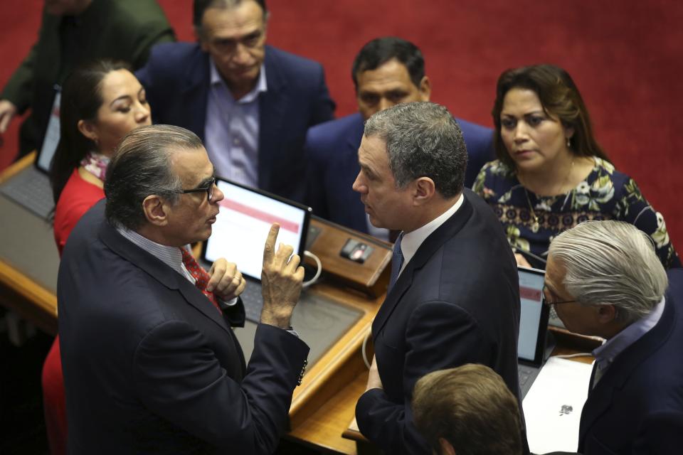 Flanked by lawmakers, President of the Peruvian Congress Pedro Olaechea, left, and Prime Minister Salvador del Solar, have a discussion inside the Congress building in Lima, Peru, Monday, Sept. 30, 2019. The political duel between Peruvian President Martin Vizcarra and Congress intensified in recent weeks after lawmakers decided to shelve Vizcarra's proposal to hold early presidential and congressional elections, which he argues is necessary to break the deadlock and stabilize the nation. (AP Photo/Martin Mejia)