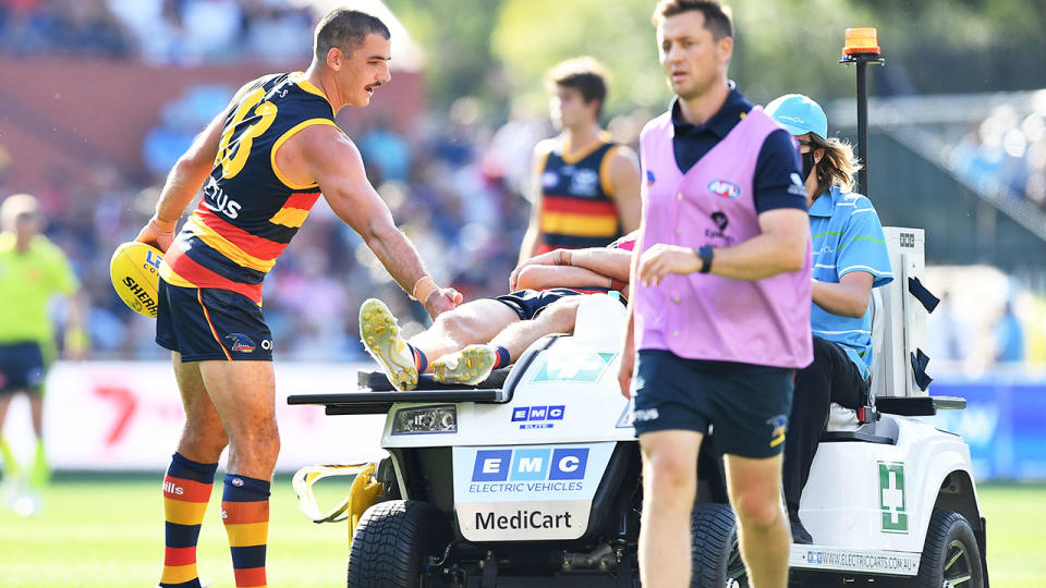 Seen here, Adelaide's Jake Kelly is taken from the ground after a sickening head clash.