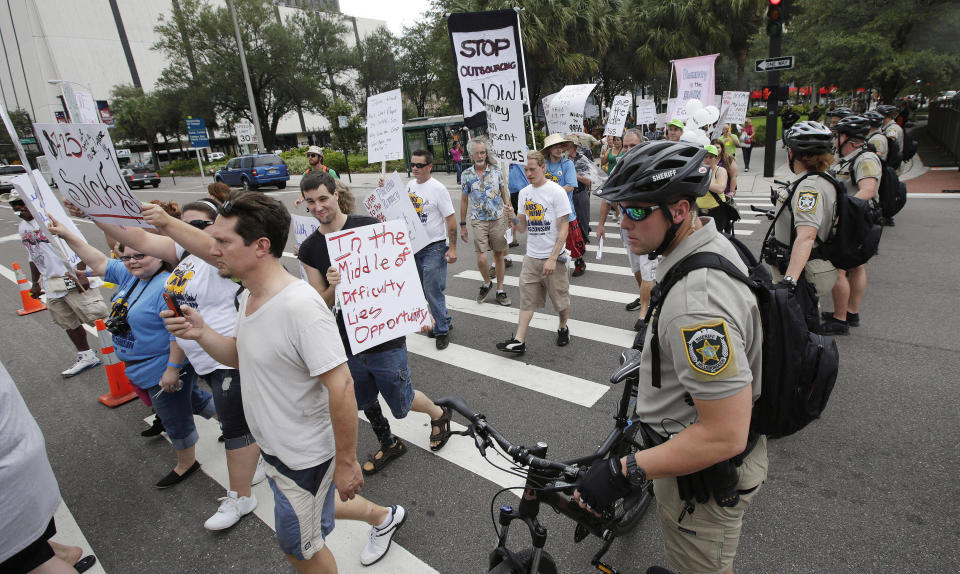 Demonstrators march, in Tampa, Fla., Sunday, Aug. 26, 2012. Hundreds of protestors gathered in Gas Light Park in downtown Tampa to march in demonstration against the Republican National Convention. (AP Photo/Dave Martin)