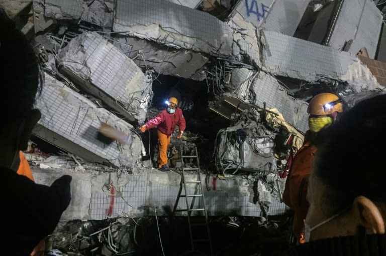 A rescue worker searches through rubble of a building which collapsed in a 6.4 magnitude earthquake, in the southern Taiwanese city of Tainan on February 9, 2016