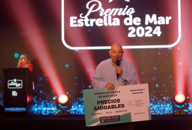 Carlos Rottemberg sosteniendo el ticket de precio amigable que ganó un Estrella de Mar