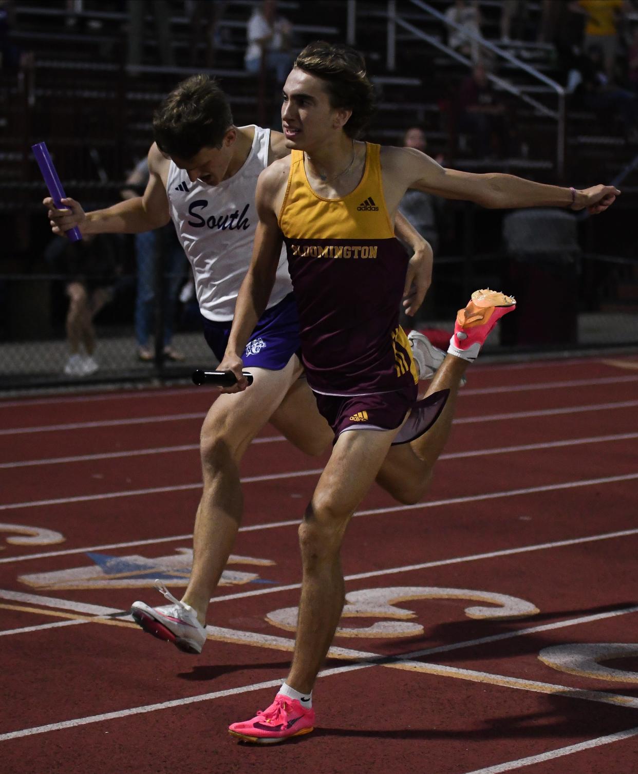Bloomington North’s Caleb Winders wins the 1,600 meter relay against Bloomington South’s Josh Tait during the track meet at North on Wednesday, May 1, 2024.