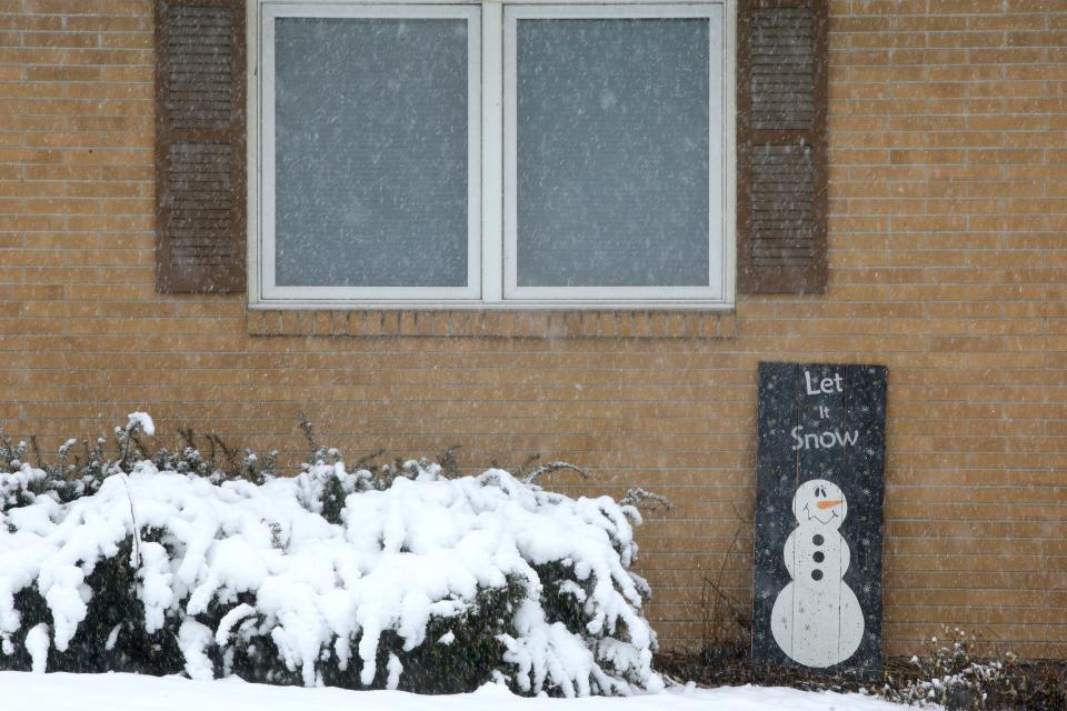 A "Let it Snow" sign is pictured outside a home on Oakcrest Street as snow falls Tuesday, Jan. 9, 2024 in Iowa City, Iowa.